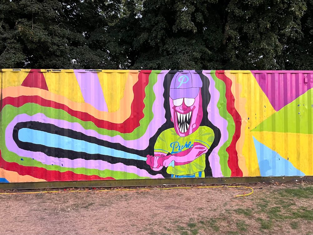 Multicolor mural of Dillon the Pickle mascot on side of shipping container 