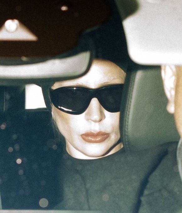 lady gaga no carro após desembarcar no rio de janeiro. a diva usa um óculos escuro, touca e roupa preta. o look era pra passar despercebida, mas o flash da foto revelou a alma da diva, revelando sua pós-vontade de pisar em terras tupiniquins.