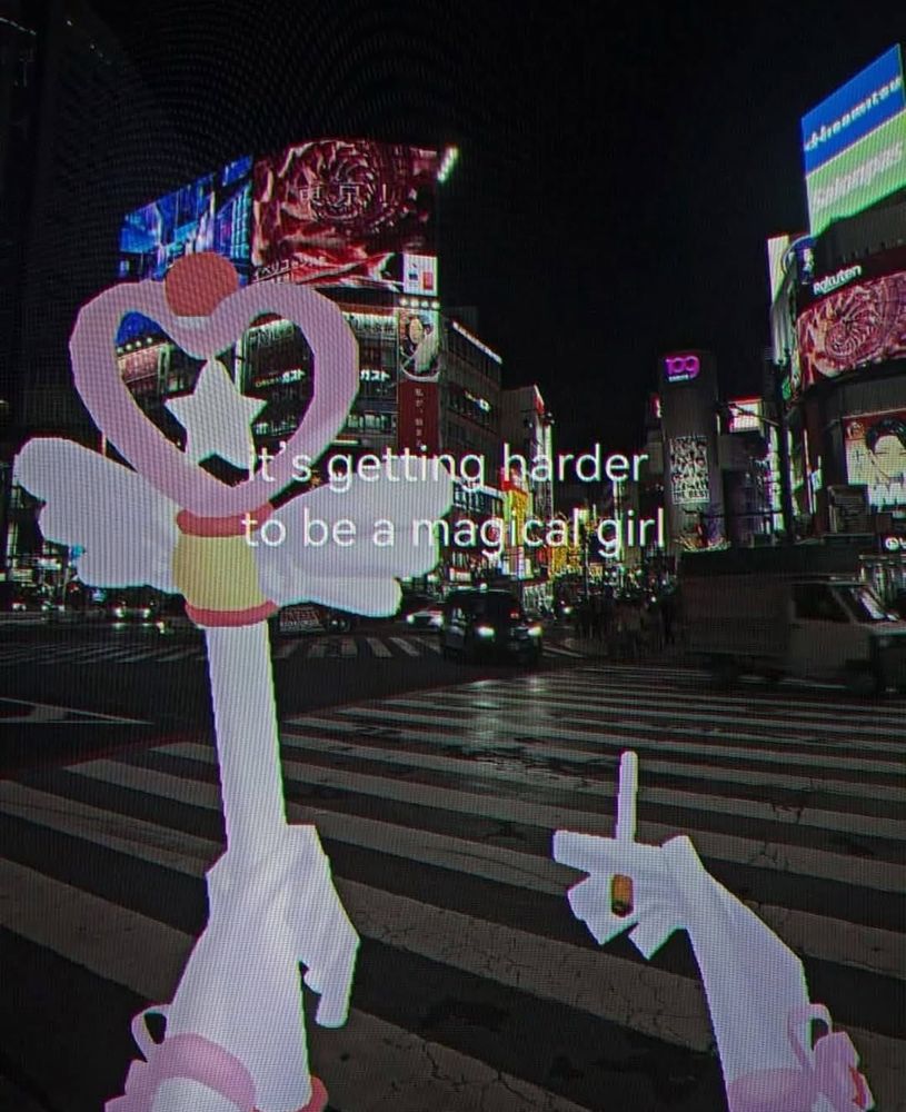 someone holding a heart shaped wand and a cigarette, with a busy city at night. the text reads “it’s getting harder to be a magical girl”
