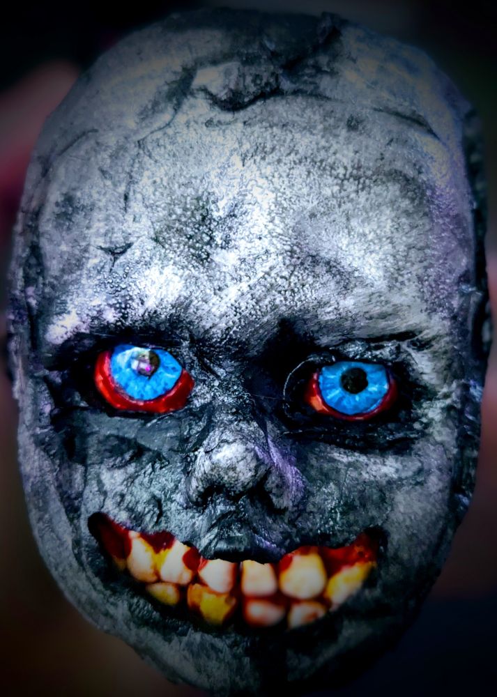 Creepy doll with blue eyes and big ugly teeth. 