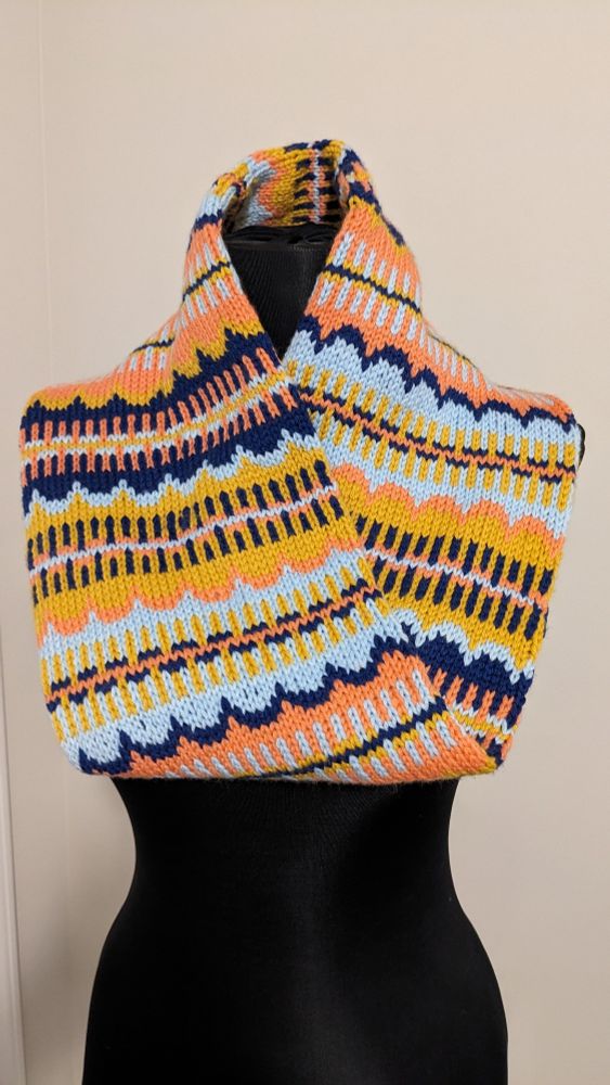 Stranded colorwork in various curves and stripes in navy blue, light blue, goldenrod and coral