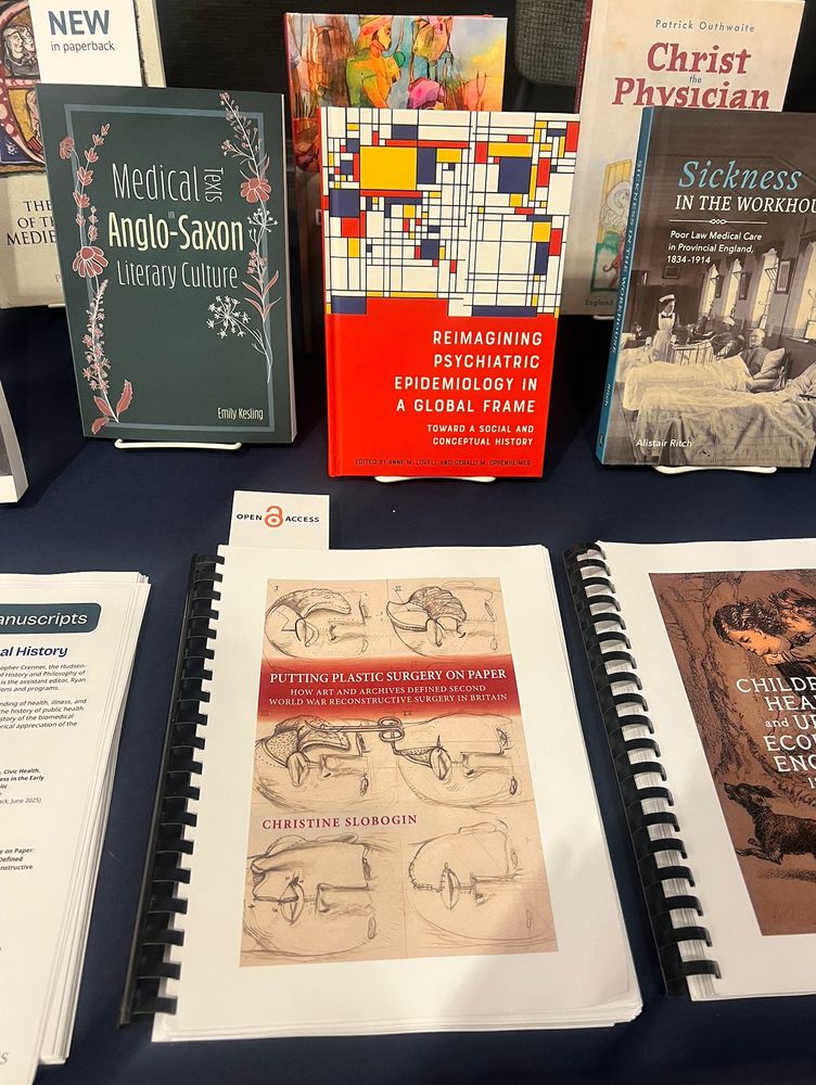 A table with several books and two printed galleys of books, including _Putting Plastic Surgery on Paper: How Art and Archives Defined Second World War Reconstructive Surgery in Britain_