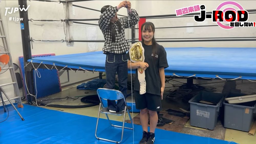 Miu Watanabe standing next to a tape measurer representing J-Rod's height as held by the goblin, Uta