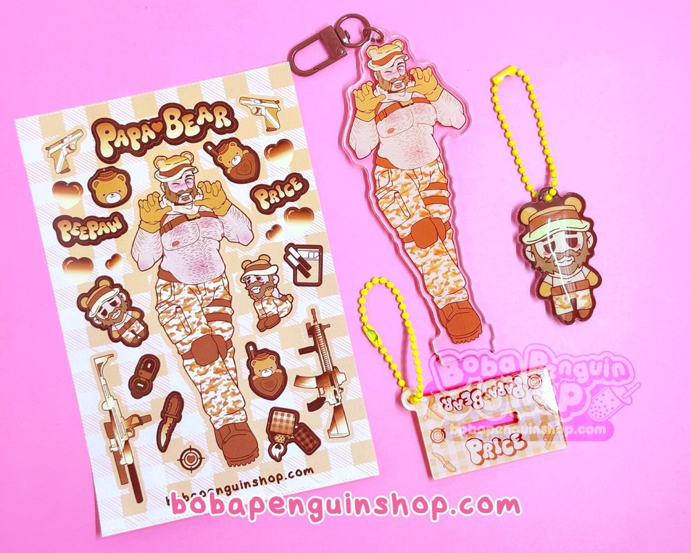 photo spread of the papa bear price v2 items. Included on the left is the sticker sheet, the acrylic charm + base version, and the older pvc charm version of price 