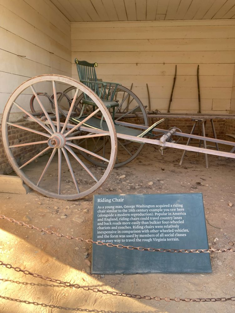 Photo of a “riding chair” I snapped a photo of at Mt Vernon which looks like a regular chair fastened onto a flat platform with a giant wheel on each side, like a chariot but without the structure in front to hold onto. 
There is an explainer plague in the photo which reads 
“Riding Chair
As a young man, George Washington acquired a riding chair similar to the 18th century example you see here (alongside a modern reproduction). Popular in America and England, riding chairs could travel country lanes and back roads more easily than bulkier four-wheeled chariots and coaches. Riding chairs were relatively inexpensive in comparison with other wheeled vehicles, and the form was used by members of all social classes as an easy way to travel the rough Virginia terrain.”