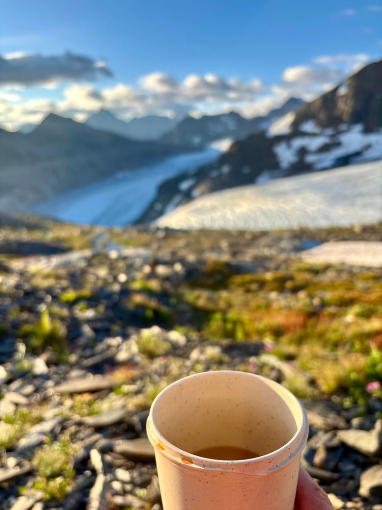 Idyllic Scene of a Coffee cup focused in the foreground, glacier in the background 