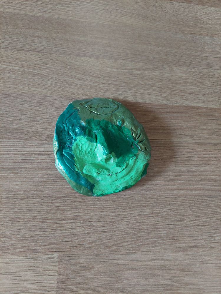 A face made of clay painted in shades of green