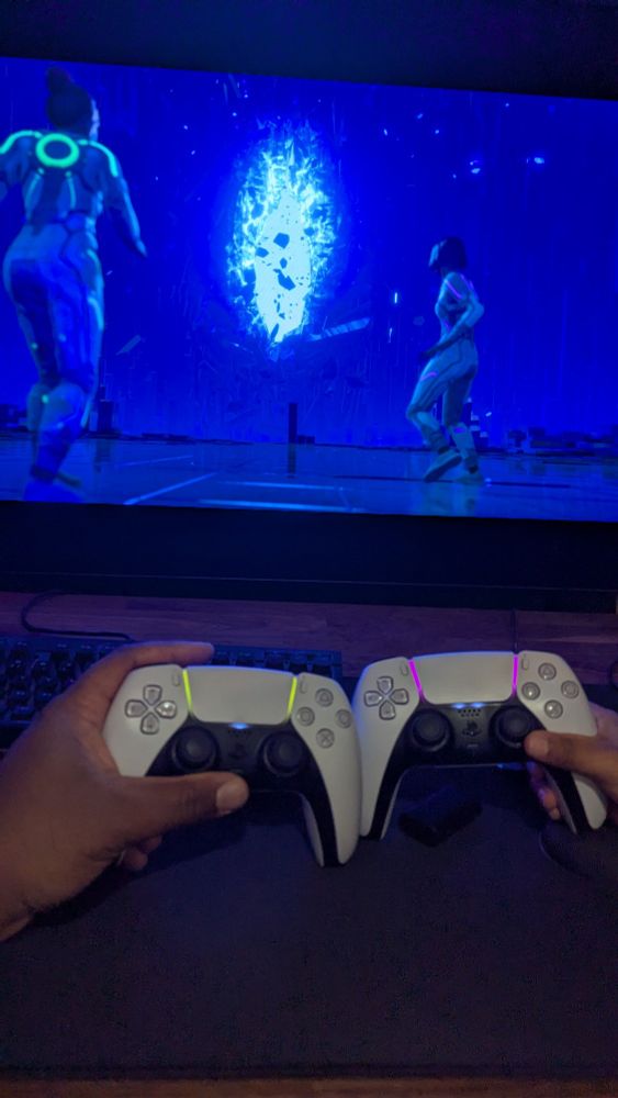 Deux manettes PS5 devant le jeu Split Fiction