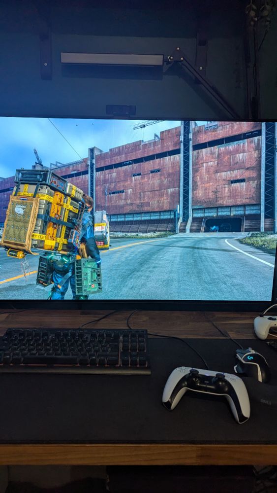 Une photo du jeu Death stranding, le personnage se tient devant une grande porte métallique 