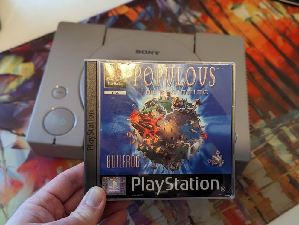 Populous game box with a PlayStation in the background 