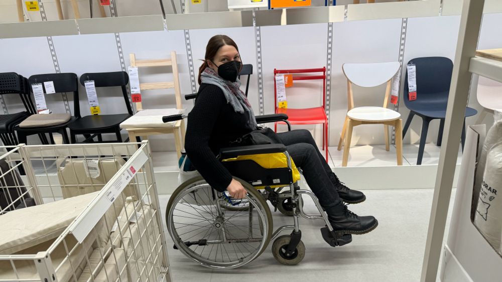 Eine Frau mit Maske im Rollstuhl bei Ikea.