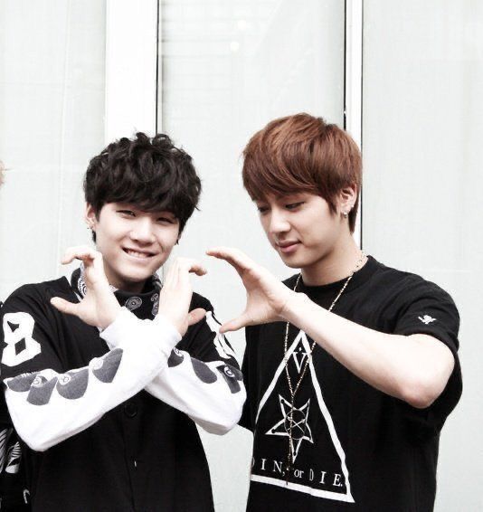 Rookie babies Yoongi and Jin are wearing black and white and making some kind of a heart sign where Yoongi has his hands crossed in front of him which looks more like a gang sign especially if you look at his smug face as well, and Jin’s left hand is like pacman trying to eat Yoongi’s gang sign heart