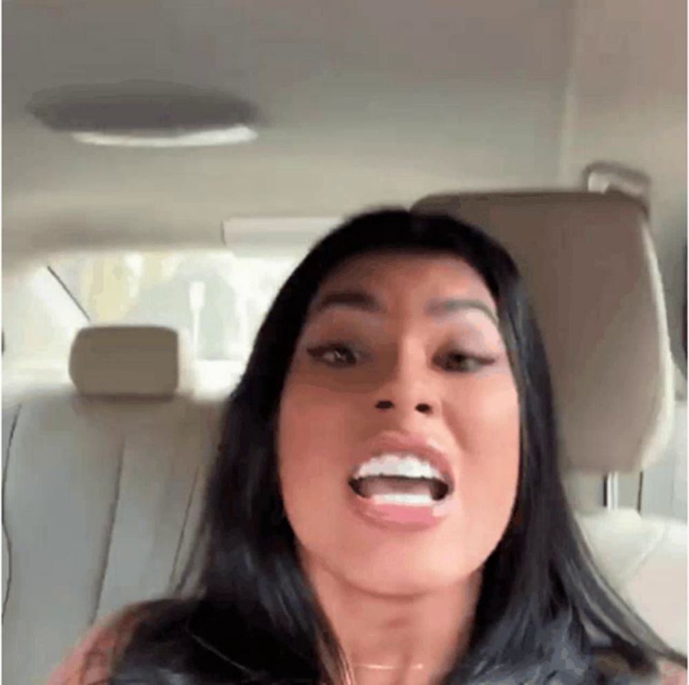 a woman is sitting in the back seat of a car with her mouth open and making a funny face .