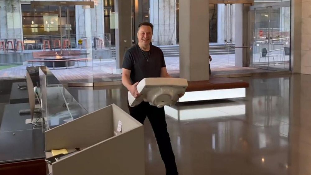 Elon Musk entrando na sede do Twitter com uma pia na mão no momento que ele decidiu comprar a empresa.
