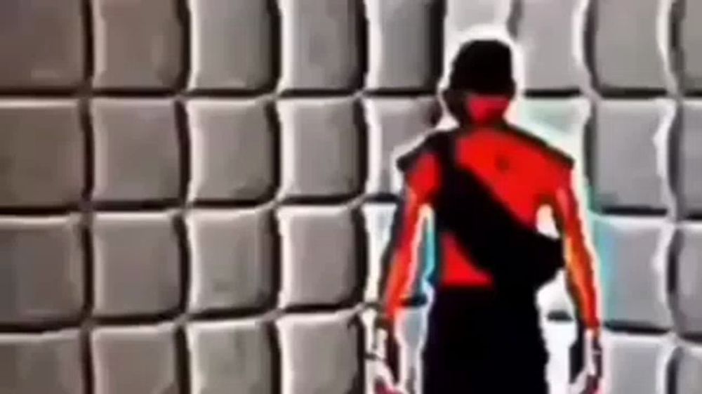 a person in a red shirt is standing in front of a wall .