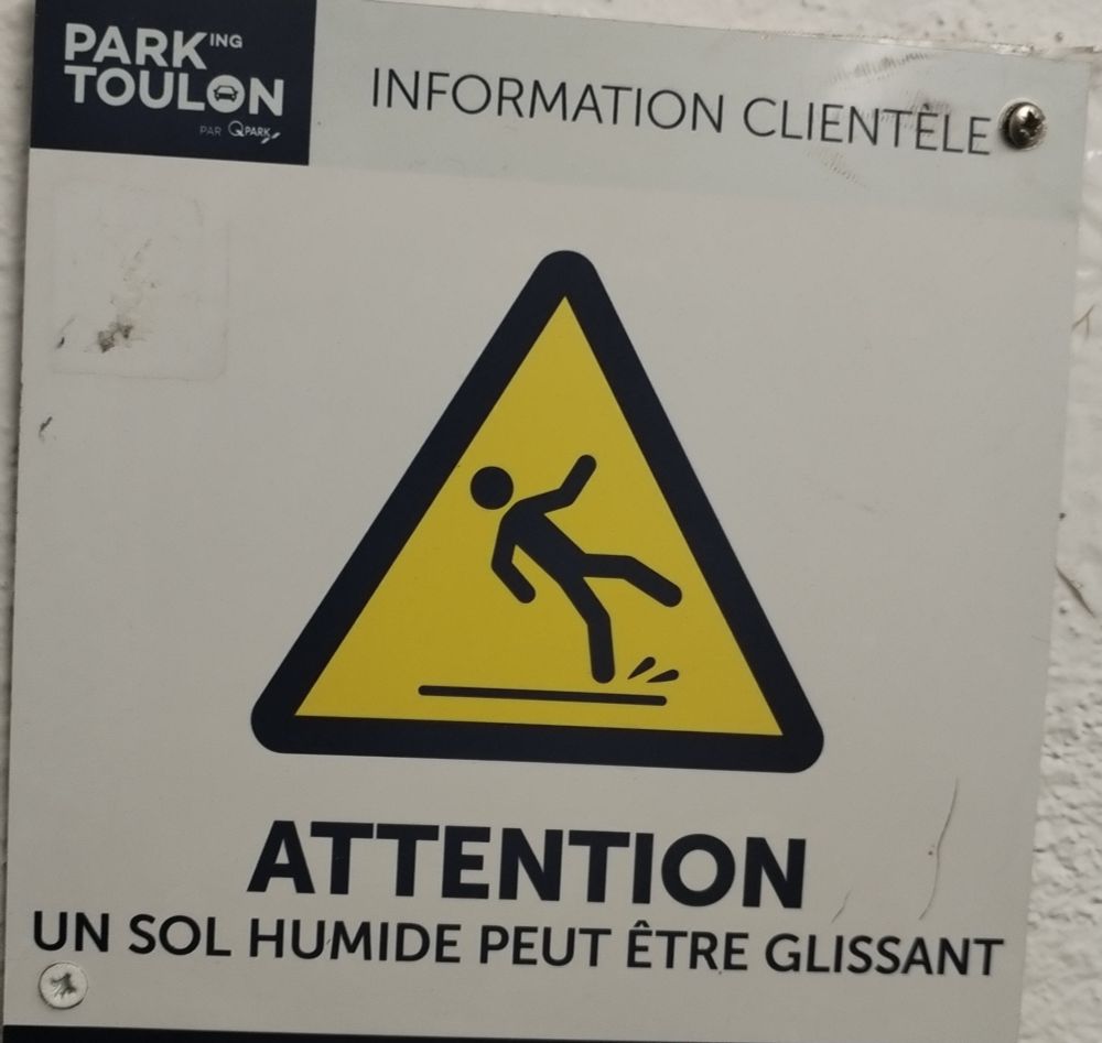 Panneau de danger avec marqué Attention, un sol humide peut être glissant 