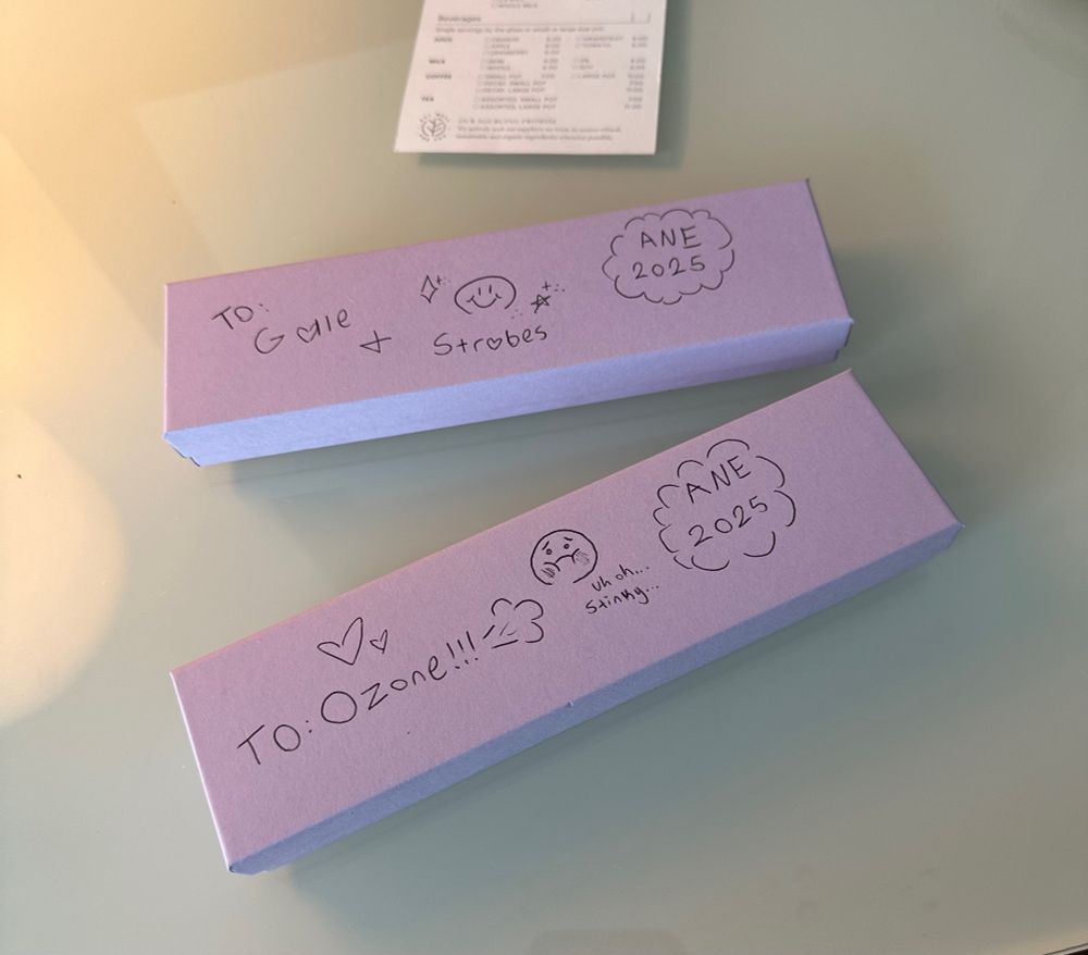 Two purple jewelry boxes laying on a table. One reads “To Gale and Strobes ANE 2025”. The other reads “To Ozone ANE 2025”