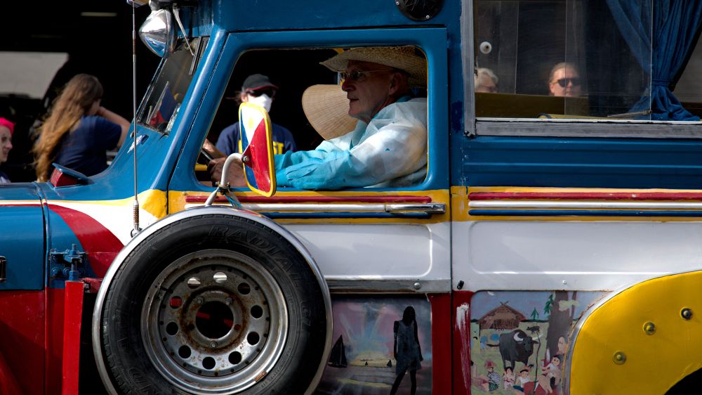Photo of person driving the Mabuhay Filipino, multi color Philippines themed Jeepney truck