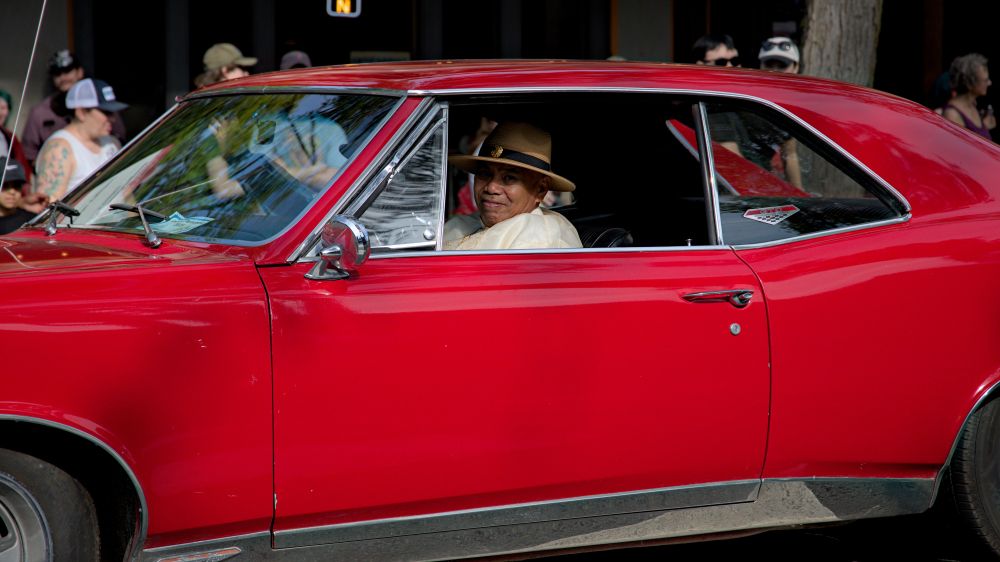 Photo of person driving by in classic Pontiac GTO red car