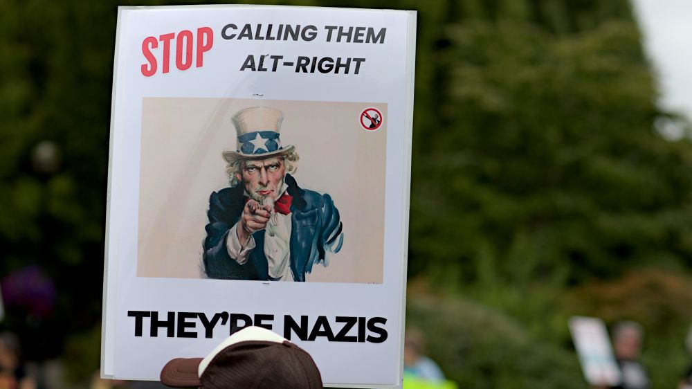 Olympia Washington, protest sign, Stop calling them Alt-Right, they're Nazis, Uncle Sam pointing, Elon Musk doing salute with a red slash through it