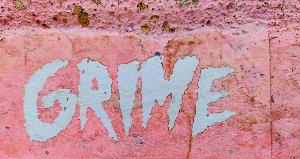 The word GRIME on a pink-painted concrete wall