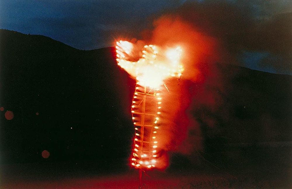 An effigy of a woman on fire, on a dark night 