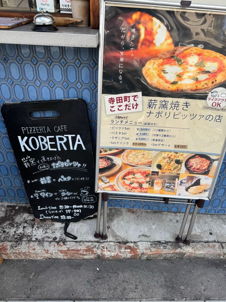 外看板。「寺田町でここだけ　薪窯焼きナポリピッツァの店」と書いてある