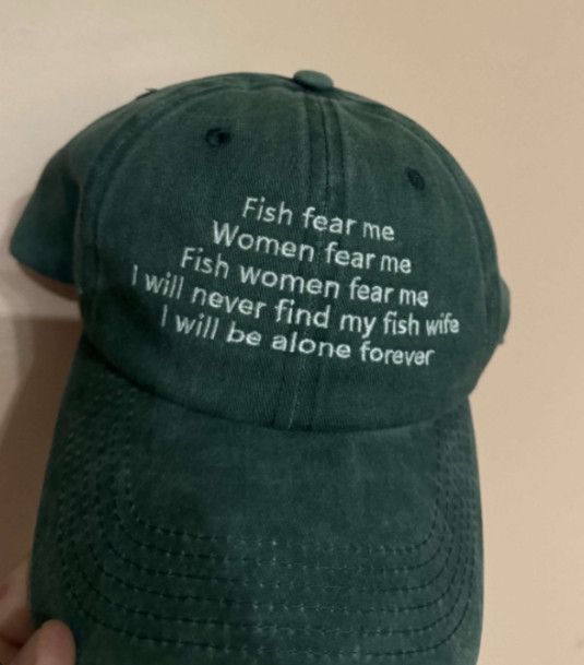 A green hat with white text that says Fish fear me
Women fear me
Fish women fear me
I will never find my fish wife I will be alone forever