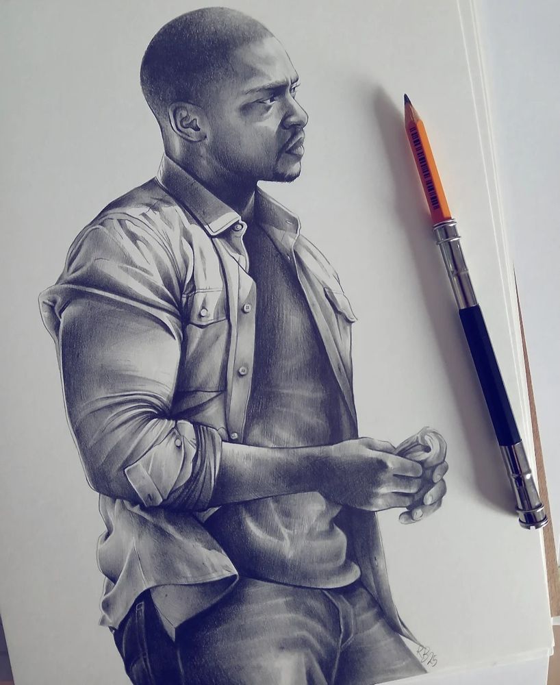 Pencil drawing on paper of Sam Wilson aka. Captain America. He is dressed casually, for working on his boat, and holding a rag in his hands. He looks to the side as if weighing up what someone is saying. Pencil with extender is beside the drawing on the page.