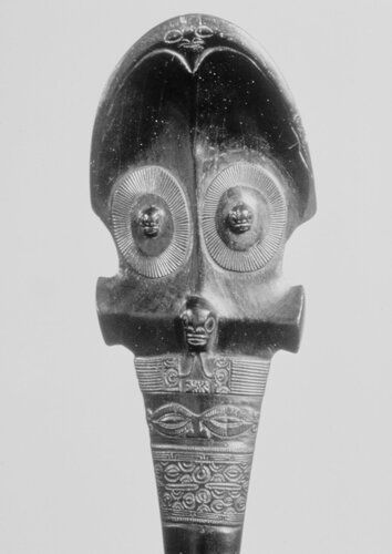 Dark brown hardwood chief's staff. Incised decoration on shaft. Head in relief at top of shaft, three humans as decoration on both sides of head.

Condition: good