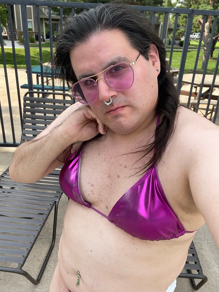 Selfie of Scarlett with pink and gold aviator sunglasses and a shiny purple bikini