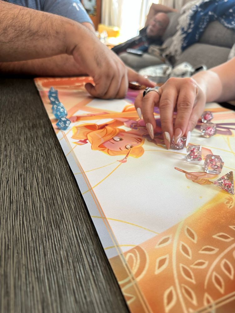 Photo of a Rapunzel play mat with a set of see-through blue dice and a transparent set of dice on top. 