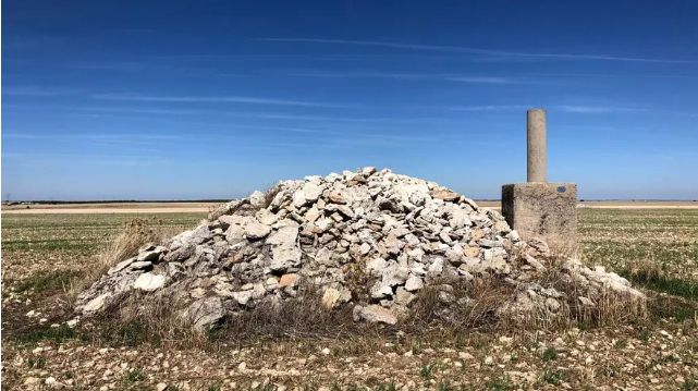 Un vértice geodésico al lado de un montón de pedruscos en mitad del páramo.