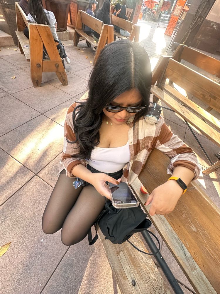 Woman looking at her phone with Vergil Capcorom on her shoulder looking as well.