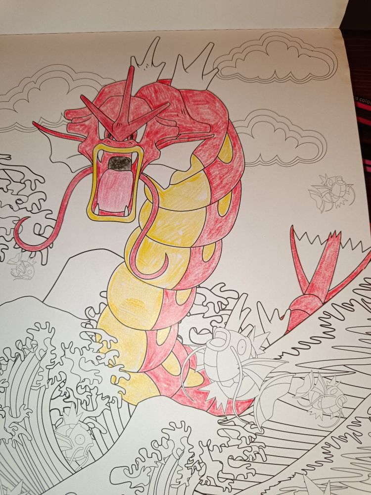 Ein Pokémon Ausmalbild mit vielen Karpadors und einem Garados im Meer. Nur das Garados wurde rot angemalt, alles andere ist schwarz-weiß. 