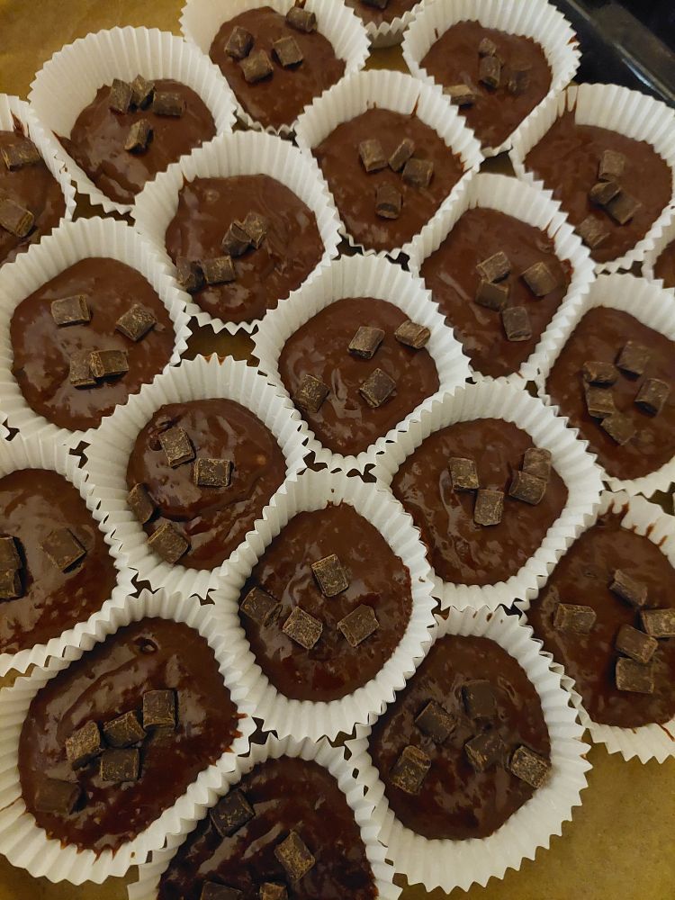 Auf dem Bild sind um die 20 Schokomuffins in weißen Papierchen zu sehen