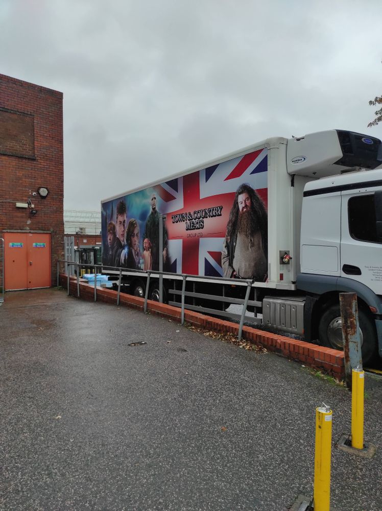 The side of a lorry featuring the Harry Potter movie characters & a Union Jack background with 'Town & Country Meats'