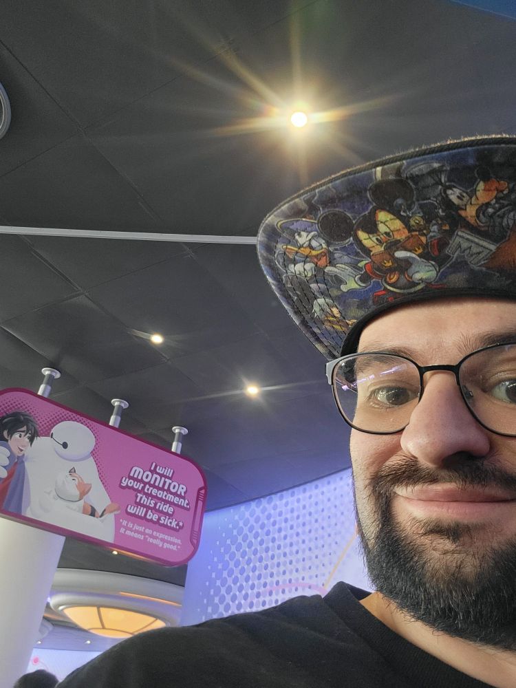 Me next to the sign that reads, "I will monitor your treatment. This ride will be sick.* It is just an expression. It means 'Really good'".