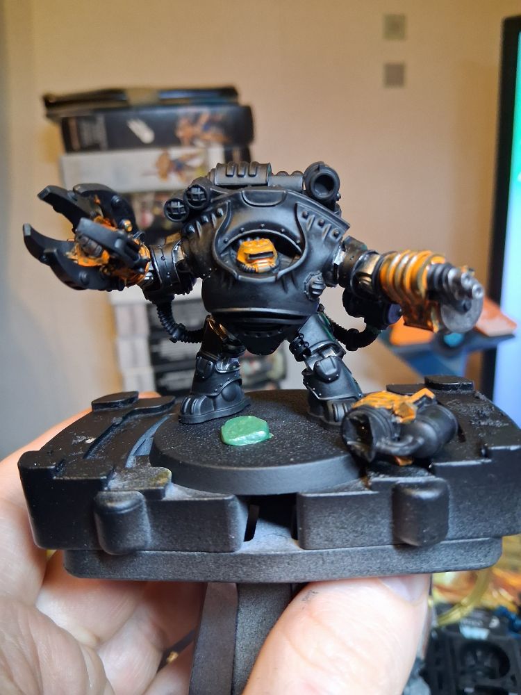 Squat exo suit in black, some.silber detail in the joints visible, a thin coat of orange on the helmet, claw, and weapon options