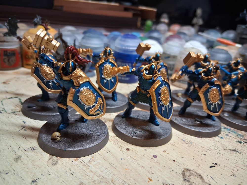 Stormcast eternals liberators with cobalt armour and gold trim, the leader has a red helmet plume. They stand on silver bases