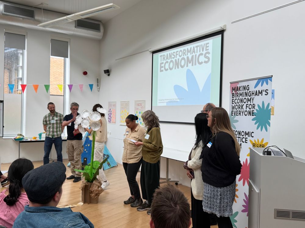 8 people presenting to an audience on transformative economics in Birmingham