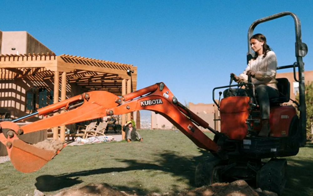 A character in Pluribus operating a Kubota excavator