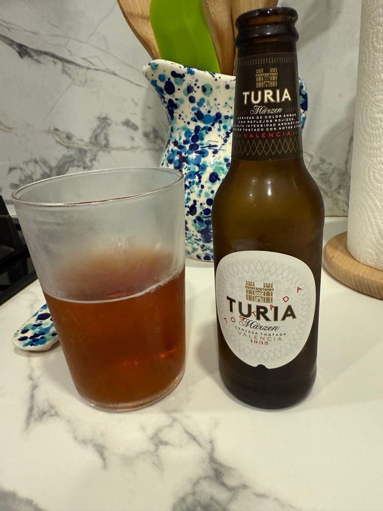 Picture of a cold mug of Turia amber beer from Valencia with the 8 oz beer bottle next to the mug.