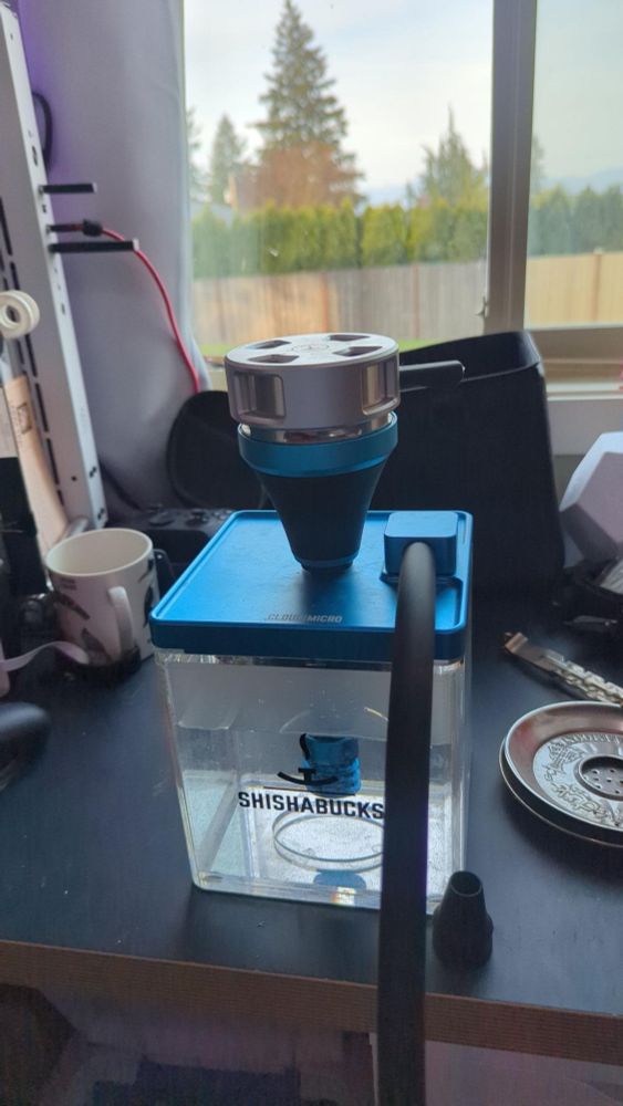 A small form factor hookah with a blue lid and bowl sitting on top of a desk