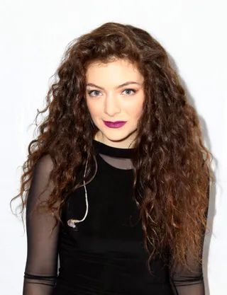 photo of lorde with curly hair wearing a black outfit 