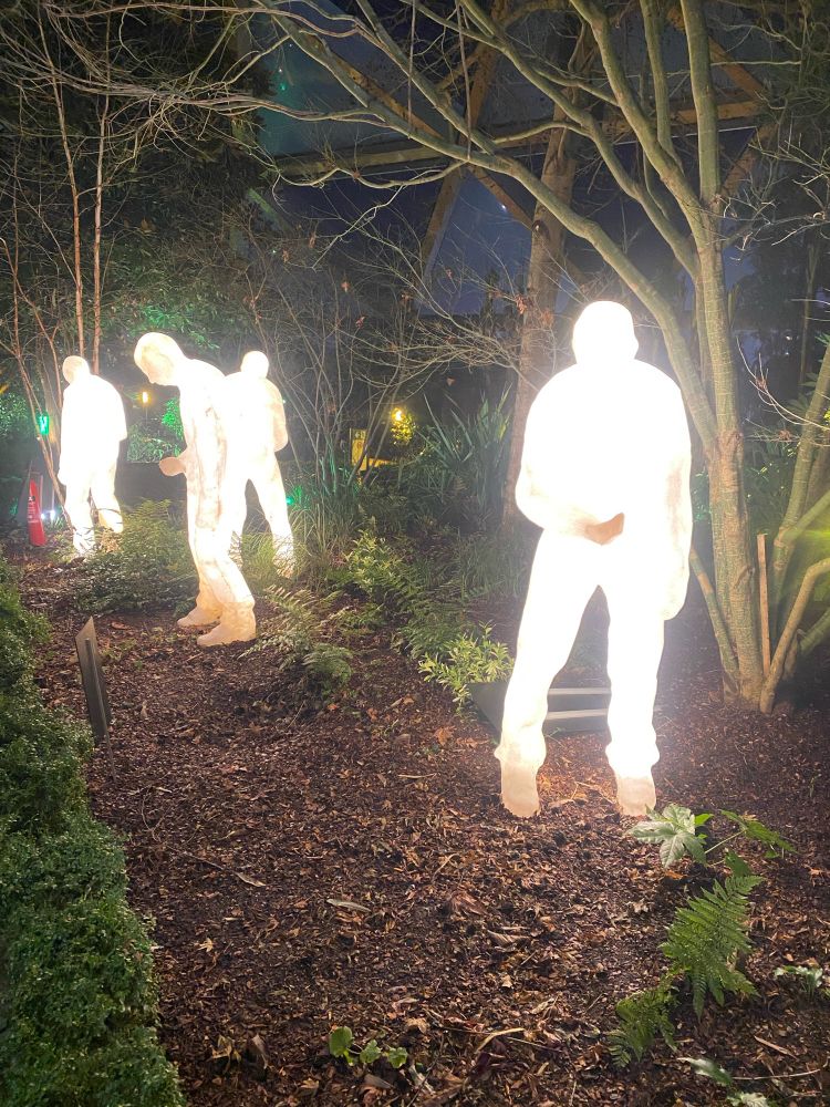 Four glowing human statues - part of the Winter Lights festival at Canary Wharf