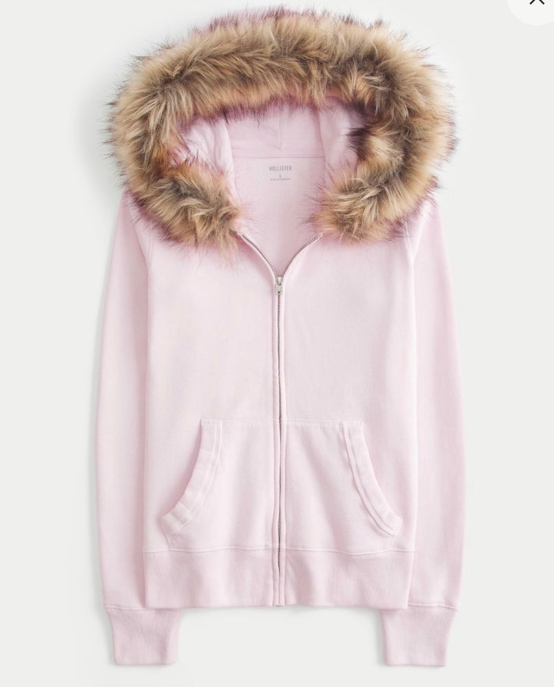 A baby pastel pink faux fur fleece hoodie. Faux fur-trimmed hood with a full zip up that has pockets and is long sleeved.