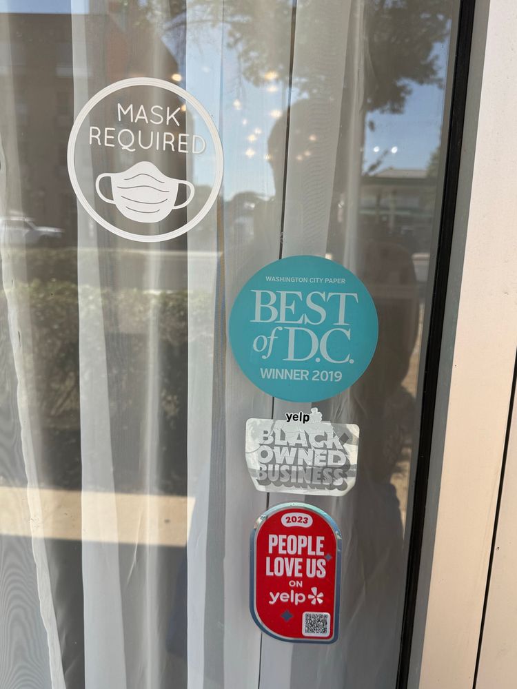 Storefront with stickers: “Mask Required,” “Best of D.C.,” and “Black Owned Business”