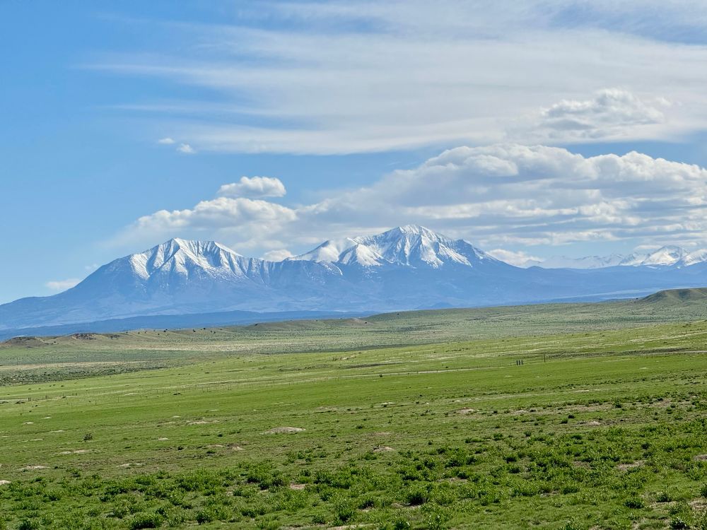 Two snow covered mountains rise above the plain 
