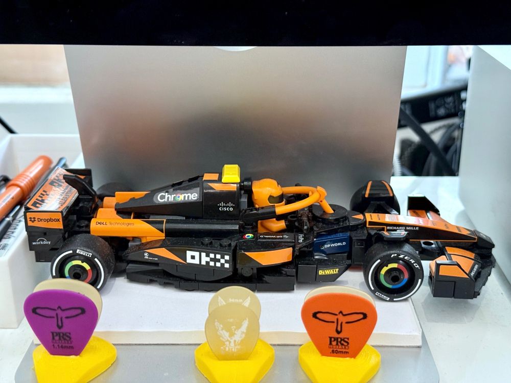 A lego F1 car in McLaren livery with a yellow T-bar instead of the stock black. 